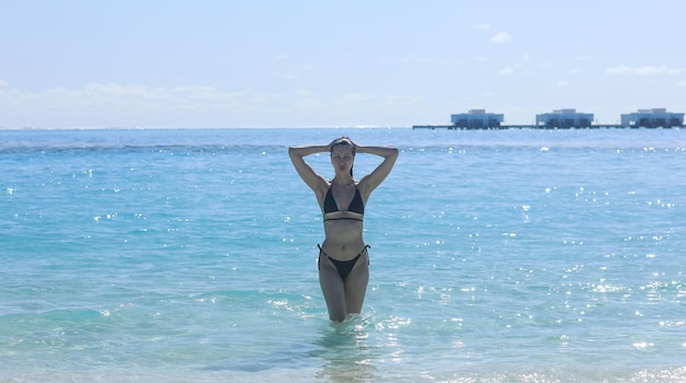 바다에서 수영하는 검은 비키니 소녀 모델