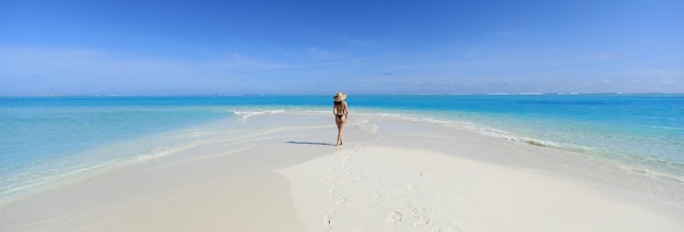 girl model in a black bikini on the white sand by the ocean