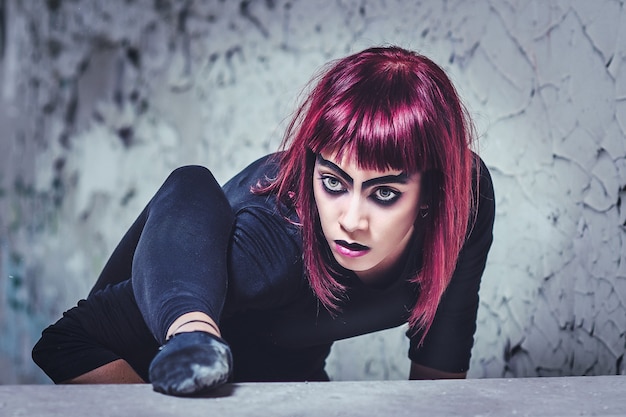 Photo girl model in black with pink hair in an abandoned building