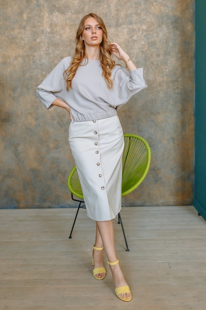 Girl model in a grey cardigan and skirt. 