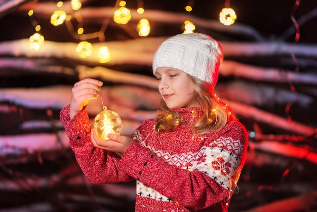 Foto modello della ragazza che tiene un giocattolo dell'albero di natale nelle sue mani