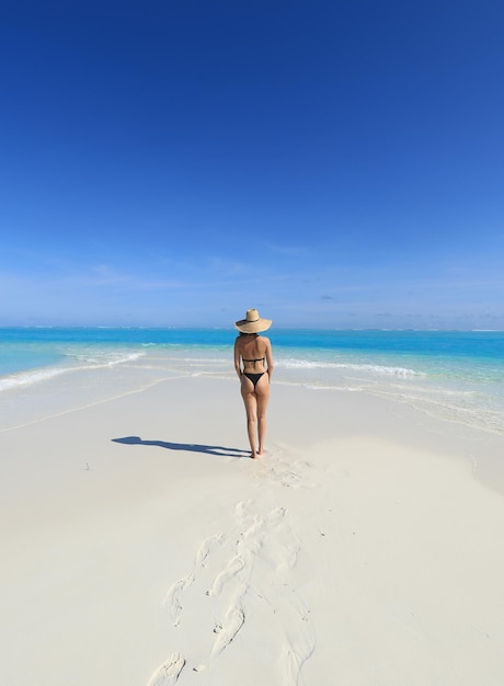 바다의 하얀 모래에 검은 비키니 소녀 모델