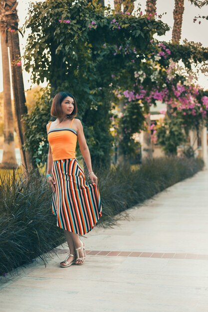 Girl model posing among palm trees on vacation in the tropics. Vacation in a warm country by the sea.