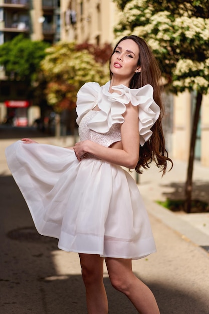 Photo girl model in a white dress on the street