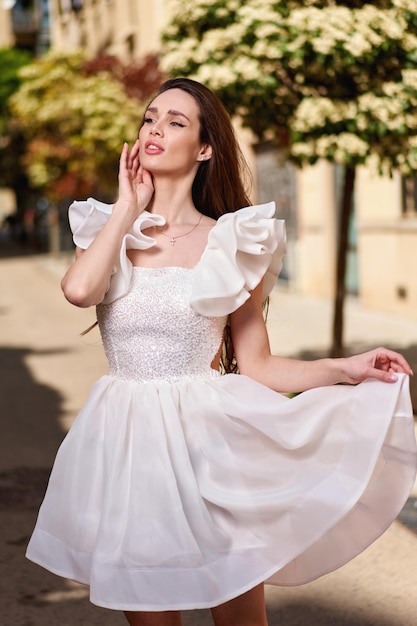 Girl model in a white dress on the street