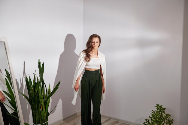 Girl in modern clothes stands on a white background