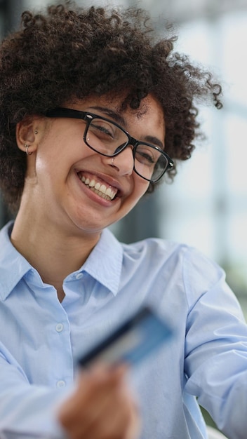 a girl in a modern office pays for purchases on the internet using a credit card