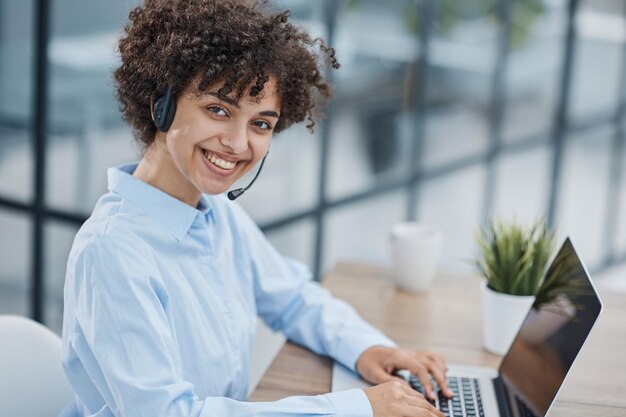 Photo girl in a modern office working in a call center smiling