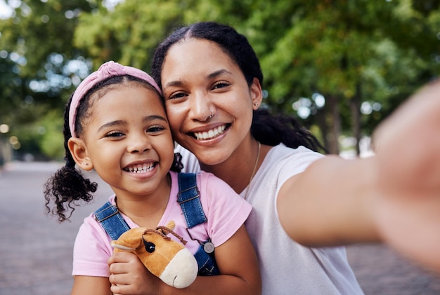 Girl mom and selfie of a mother and kids portrait in a park with a happy smile outdoor Happiness family and mama love with parent care for child on vacation together of a woman and young person