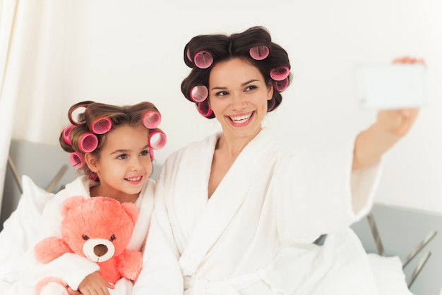 Photo girl and mom take selfie together.