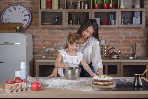 Girl and mother cook a cake