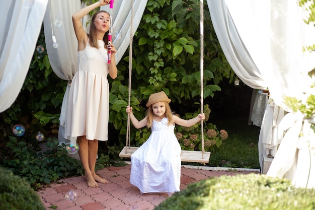 Girl and mother having fun playing outdoors on summer day