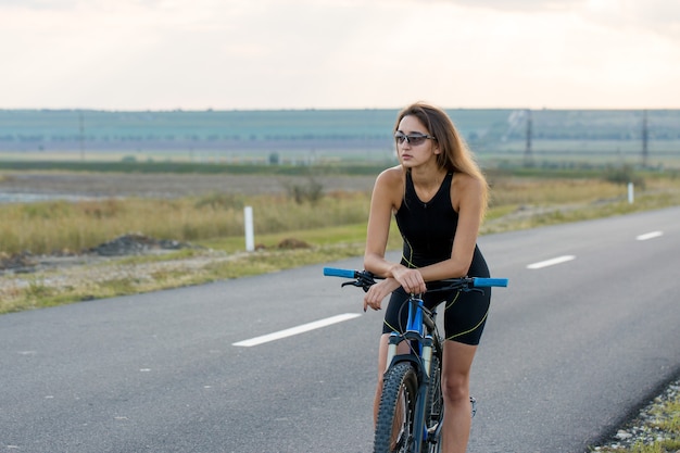 Girl on a mountain bike on offroad beautiful portrait of a cyclist girl rides a modern carbon  bike