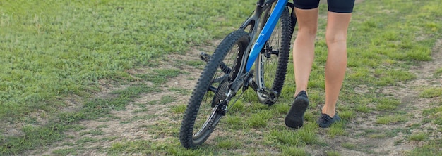 Girl on a mountain bike on offroad beautiful portrait of a
cyclist at sunset fitness girl rides a modern carbon fiber mountain
bike in sportswear