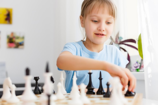 Girl moving a counter while playing chess