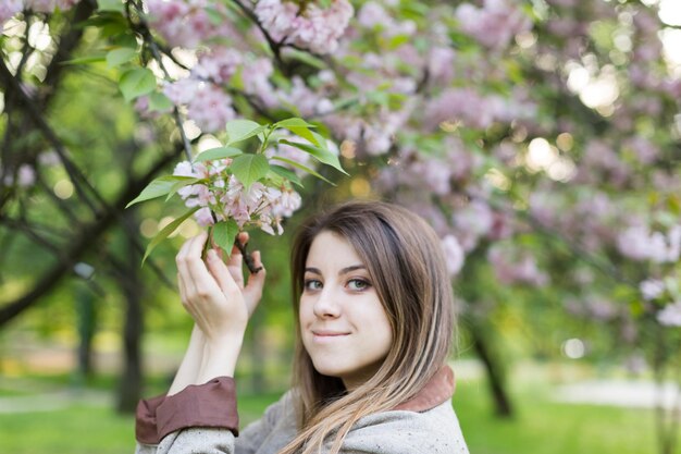 girl near blooming sakura. Spring is now. Cherry blossoms. Sakura at dusk. portrait at sunset