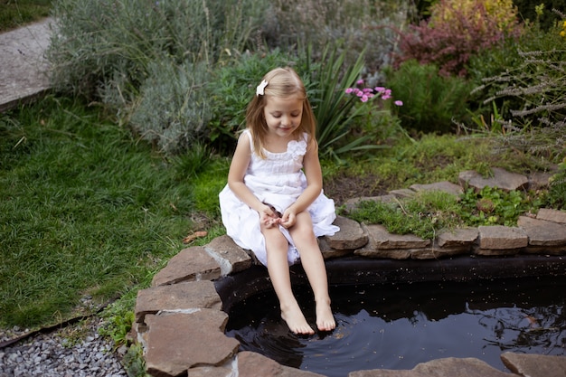 Girl near pond enjoying sunny summer day