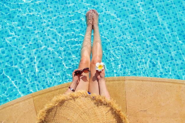 Girl near the pool with a flower. People.