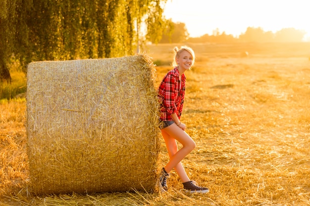 Photo girl near a stack in the field