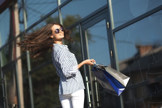 A girl near the wall of a shopping center.