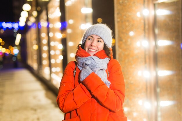 Ragazza in una città di notte fiocco di neve natale luci della città natale e vacanze invernali concept