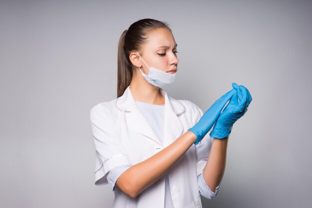 Girl nurse in gloves examines something carefully at the tips of her fingers