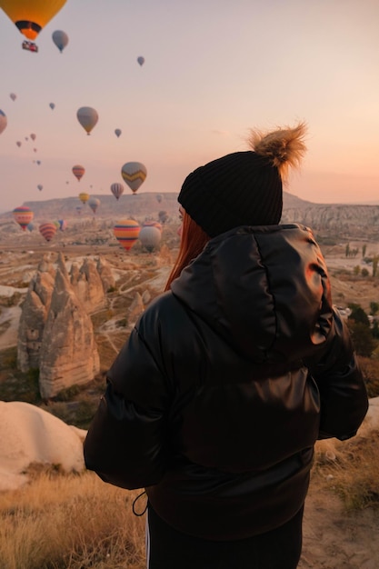 写真 熱気球の背景で地平線を観察する女の子