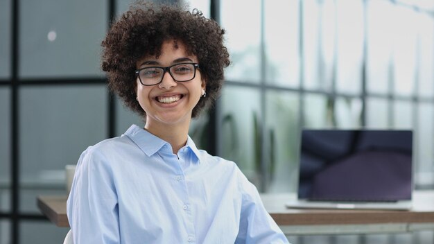 Photo girl in the office smiles expresses success and leadership is thinking about success