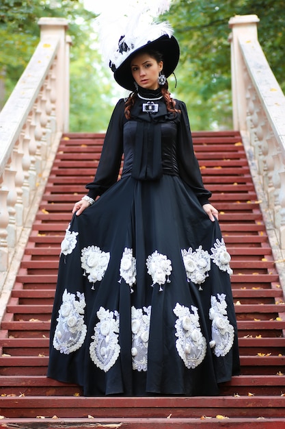 Girl in old retro dress on stairs outdoor