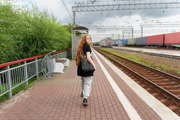 写真 電車を待っている搭乗ホームの女の子