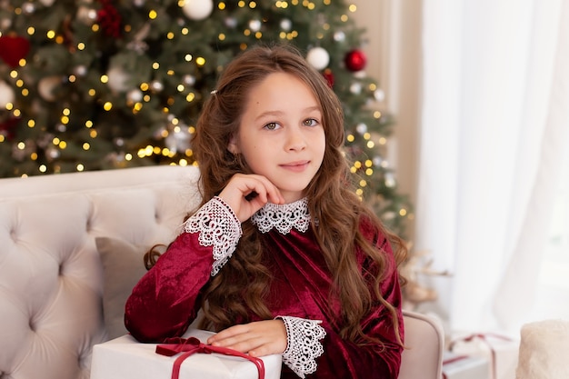 girl opens Christmas gift in living room