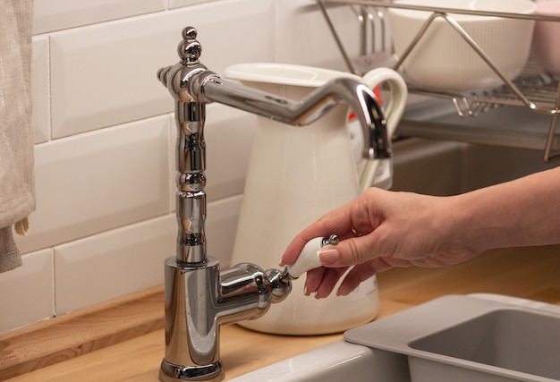 The girl opens the faucet for washing hands, concept of health