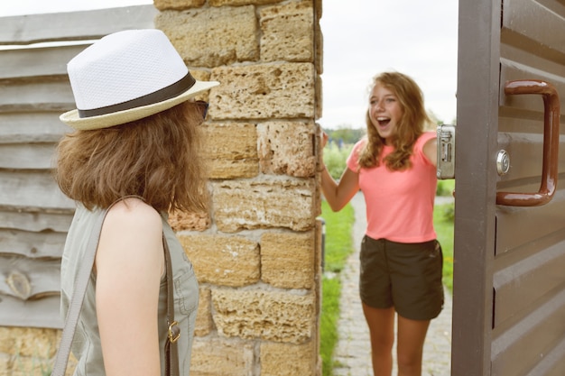 Girl opens front door to her friend