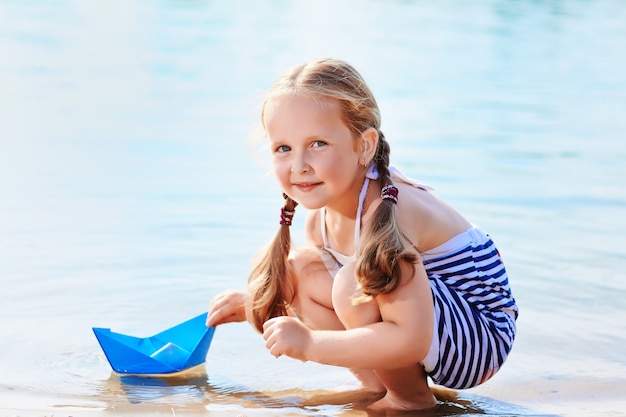 Girl and origami boat outdoor