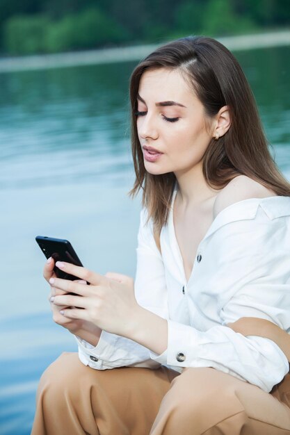 写真 外で携帯電話でメッセージを送っている女の子 ⁇ 携帯電話を持っている女の子 ⁇