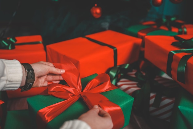 Photo girl packing gifts near the christmas tree