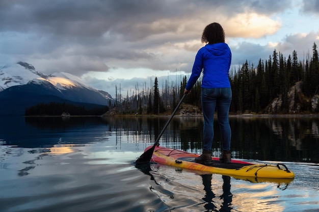 Girl Paddle Boarding in een vredig en kalm gletsjermeer