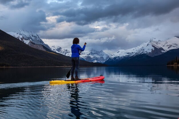 Girl Paddle Boarding in een vredig en kalm gletsjermeer