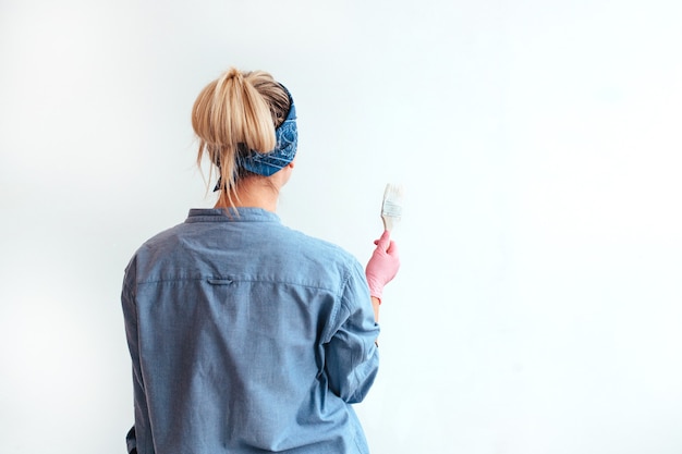 Girl paint the wall with a brush