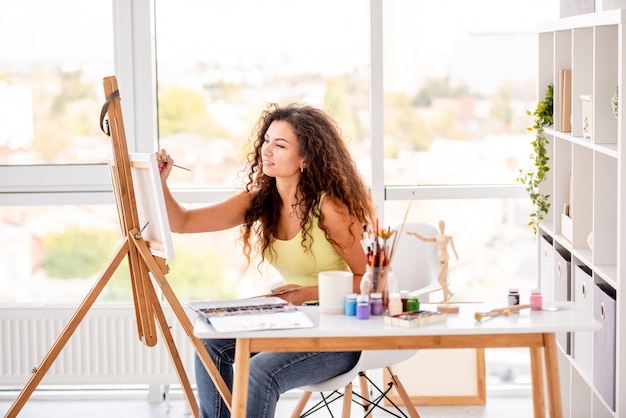 Girl painter painting indoors