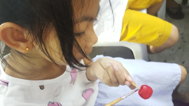 Photo girl painting lollipop