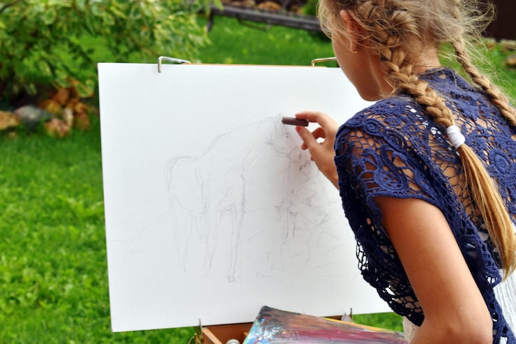 Photo girl painting a picture on an outdoor sketchbook