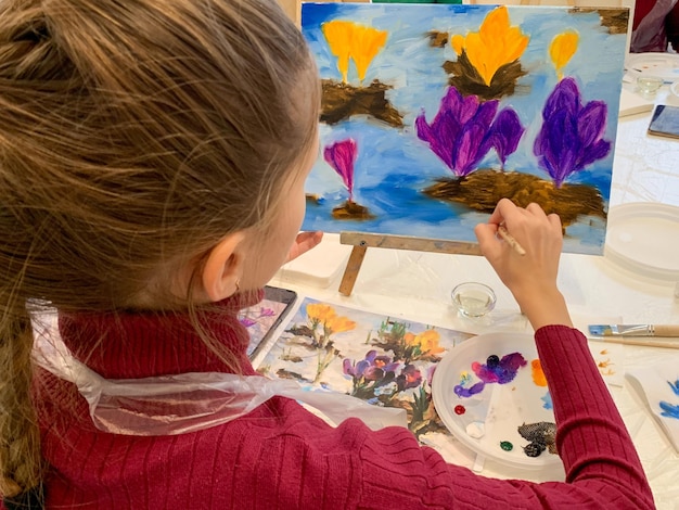 女の子はキャンバスに油絵を描く若い芸術家の職場の芸術の子供は描くことを学ぶ