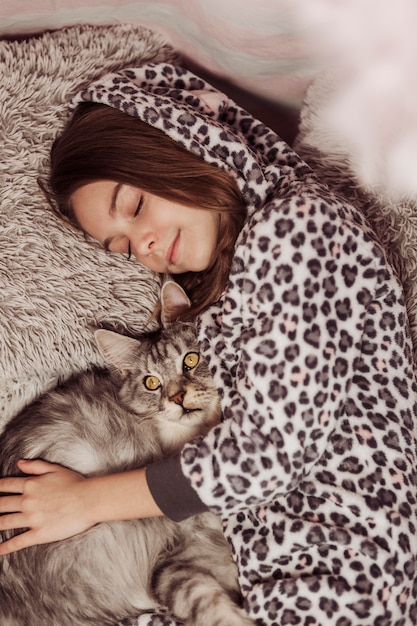 Foto ragazza in pigiama e vista dall'alto del gatto