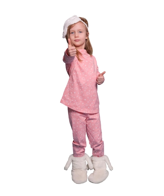 Girl in pajamas and an eye mask on a white background, shows a finger forward