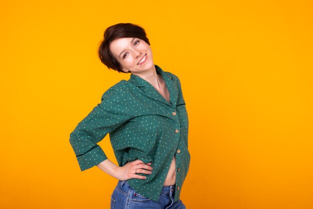 Girl in pajamas posing while resting at home on yellow background