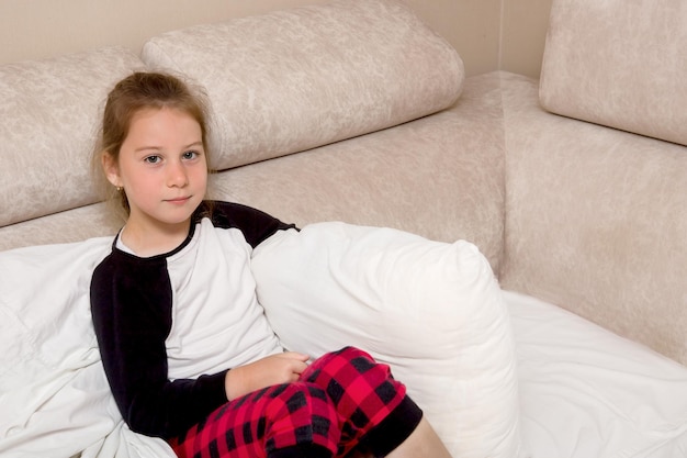 Girl in pajamas sitting in bed convalescence