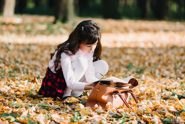 Girl in park in autumn makes lessons