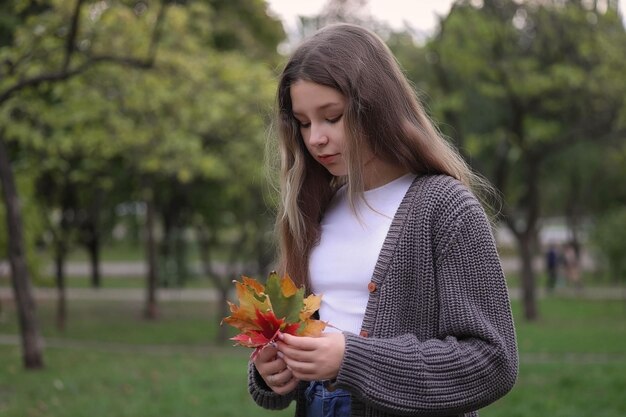 girl in the park looking at the dried leaves