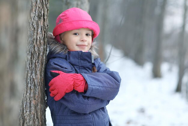 公園の冬の雪の散歩の女の子